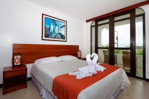 阿约拉港Galapagos Apartments - Bay View House的酒店客房,配有带毛巾的床