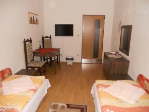 班斯卡-比斯特里察马多娜汽车旅馆的带两张床和一张桌子的房间以及一间用餐室