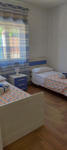 Leporano MarinaCasa vacanze Nonna Titina的客房设有两张床和窗户。