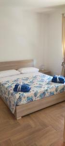 Leporano MarinaCasa vacanze Nonna Titina的一间卧室,床上摆放着蓝色鲜花
