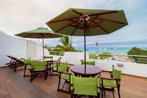 阿约拉港Galapagos Apartments - Bay View House的阳台上配有一组桌椅和遮阳伞