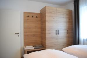 布鲁尼科Pension Hofer的一间卧室配有一张位于床边的大型木制橱柜