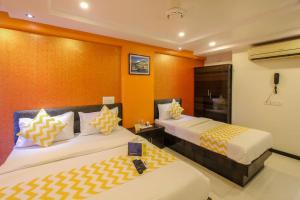 孟买PANCHVATI RESIDENCY ANDHERI WEST的橙色墙壁客房的两张床