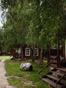 阿尼克什奇艾Laumių Nameliai的一座有树、长凳和岩石的建筑