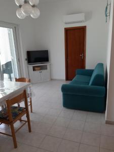 普拉A 30 metri dal mare di Nora, casa confortevole的客厅配有蓝色的沙发和桌子