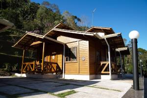 弗洛里亚努元帅镇Casa de Campo com Churrasq em Marechal Floriano - ES的街道上带门廊的小木结构建筑