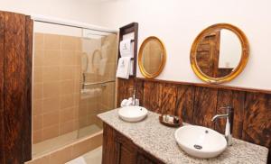 昆卡Hacienda Hostería Dos Chorreras的一间带两个盥洗盆、淋浴和镜子的浴室