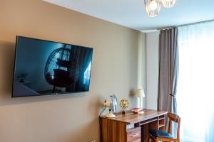 克卢日-纳波卡Thome Hoia Studio 1Bedroom的客房设有书桌和墙上的电视。
