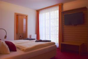 马特斯堡维森比任霍夫宾馆的一间卧室设有一张带电视和窗户的床。