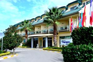 盖布泽亚洲赫格萨贡海洋酒店的棕榈树和旗帜在前面的酒店