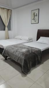 巴兰卡韦梅哈Edificio Tony - Alojamiento Aparta-Hotel的一间卧室配有两张床,床上配有毯子