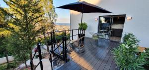 塞特港Studio terrasse Indépendante Vue Exceptionnelle的房屋顶部带遮阳伞的阳台