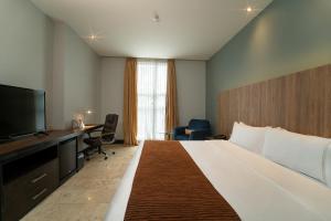 巴兰基亚GHL Hotel Barranquilla的酒店客房设有一张大床和一张书桌。