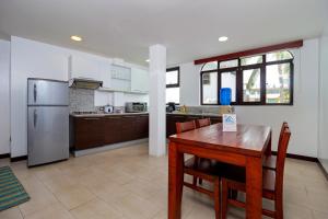 阿约拉港Galapagos Apartments - Bay View House的厨房配有木桌和冰箱。