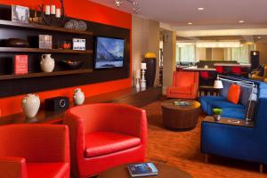 伯明翰伯明翰柱廊/汇景万怡酒店的客厅配有红色椅子和电视