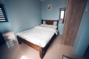 卢塞纳HK Hotel Kbartolo的一张小床,位于一个蓝色的墙壁内
