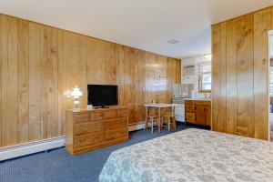 AltonKing Birch Lake Homes的一间卧室配有一张床、一台电视和一张桌子
