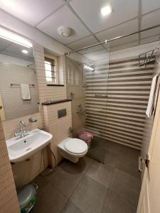 特里凡得琅RAMAS GARDEN的一间带卫生间、水槽和镜子的浴室