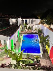 圣玛尔塔The Chill in Mansion Hostel Santa Marta的夜间房子中间的一个游泳池