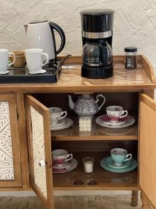 Ash Shuwaybiţminivilla的咖啡壶和木架上的杯子