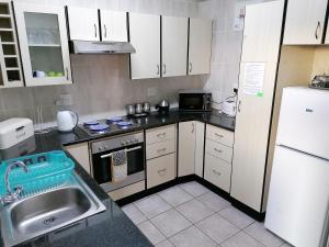 阿曼济姆托蒂Seaview Self Catering Amanzimtoti的厨房配有白色橱柜、水槽和冰箱。
