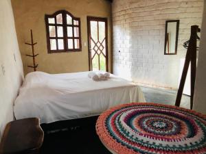 圣若热岛Shanti - Hospedaria na Vila de São Jorge的一间卧室配有一张铺着地毯的床