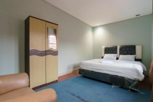 巴东Asokatama Residence Syariah Mitra RedDoorz的一间带床和沙发的小卧室