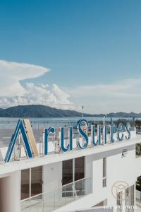 哥打京那巴鲁The Aru Hotel at Aru Suites的海滩建筑顶部的标志