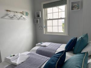 利明顿Solent Haven, Lymington with sea views and parking的一间卧室设有两张床和窗户。