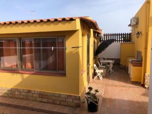 兰佩杜萨Villette ad uso turistico Lampedusa的黄色的房屋,设有庭院和桌子