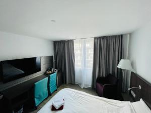 杜塞尔多夫4* Boutique Zimmer am Düsseldorf Hafen + ÖPNV & TG的配有一张床和一台平面电视的酒店客房