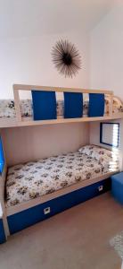 托尔托利La Dolce Vita - Casa Vacanza Tortolì-Arbatax的一间卧室配有两张双层床和蓝色枕头
