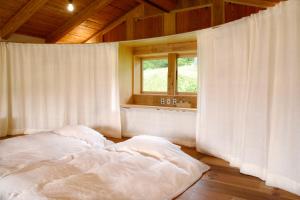 高山HAKU 100-year-old Quaint Japanese Style Villa的窗户客房内的一张白色床