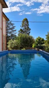 蒙塔尔奇诺VAL D'ORCIA DELUXE 2, RAFFINATA CASA immersa nel verde con WiFi, giardino e parcheggio的一座房子前面的蓝色海水游泳池