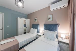 瓦尔纳Great Location Apartment的卧室设有两张蓝色和白色的床