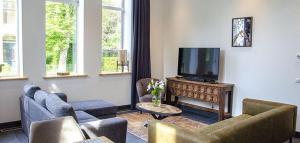 洛珀瑟姆Spoorzicht Long Stay Apartments的带沙发和平面电视的客厅