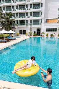 金边向日葵公寓式酒店的两个女人在游泳池里充气的木筏上