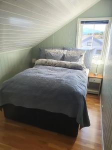 波多Idyllisk sjøhus på Naurstad的一间卧室设有一张大床和窗户