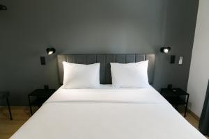 亚历山德鲁波利斯Zen Sea的一张配有白色床单和枕头的大床