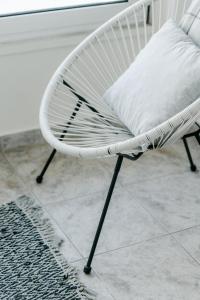 亚历山德鲁波利斯Zen Sea的瓷砖地板上配有带枕头的白色椅子