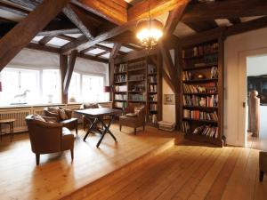 Burgbrohl布尔格布罗尔施劳斯酒店的图书馆配有桌椅和书架
