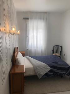 格罗韦Pensión Barqueiras 15的一间卧室配有一张带蓝色毯子的床和窗户。