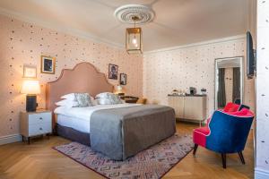 萨格勒布Hotel Capital的一间卧室配有一张大床和一张蓝色椅子