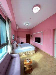 鱼池乡2H 分享家的粉红色的卧室配有床和沙发