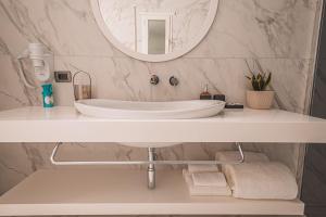 伏罗拉Grand Mirage的浴室设有白色水槽和镜子