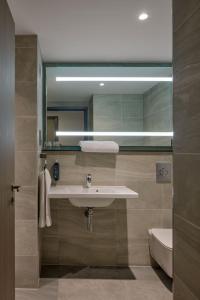 曼彻斯特Maldron Hotel Manchester City Centre的一间带水槽、卫生间和镜子的浴室