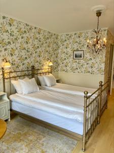瓦斯泰纳城堡花园酒店的一间卧室配有一张带花卉壁纸的大床