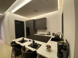 利雅德3 - Bedroom Apartment的厨房配有水槽和带椅子的柜台。