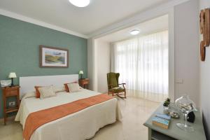大加那利岛拉斯帕尔马斯拉斯坎特拉斯海滩公寓的卧室配有床、椅子和窗户。