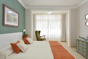 大加那利岛拉斯帕尔马斯拉斯坎特拉斯海滩公寓的卧室配有床、椅子和窗户。